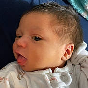 Noelle joined the competition — help win amazing prizes! newborn, baby, infant, child, portrait, face, tongue, sleepy, cozy, blanket, clothing, onesie, white, indoors, close_up, sitting, lying_down, head, eyes, family_photo