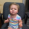 baby, child, toddler, sitting, chair, portrait, indoors, smiling, face, blonde_hair, striped_clothing, colorful, snack, hand, arm, legs, home, furniture, photograph, cute