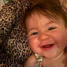 baby, child, infant, smiling, happy, portrait, close_up, face, adult, parent, cuddling, indoors, leopard_print, fabric, floral_clothing, brown_hair, family, photography, joy, cozy