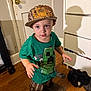 toddler, child, indoor, hat, boots, green_tshirt, minecraft, wooden_floor, dresser, shadow, curious_expression, clothing, person, floor, door, furniture, room, standing, young_child, casual
