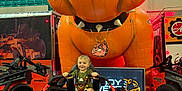 Collin Lee joined the competition — help win amazing prizes! toddler, child, lawn_mower, orange, inflatable, dog, toy, indoor, event, seat, smile, machine, vehicle, spikes, collar, bleachers, sign, floor, person, casual