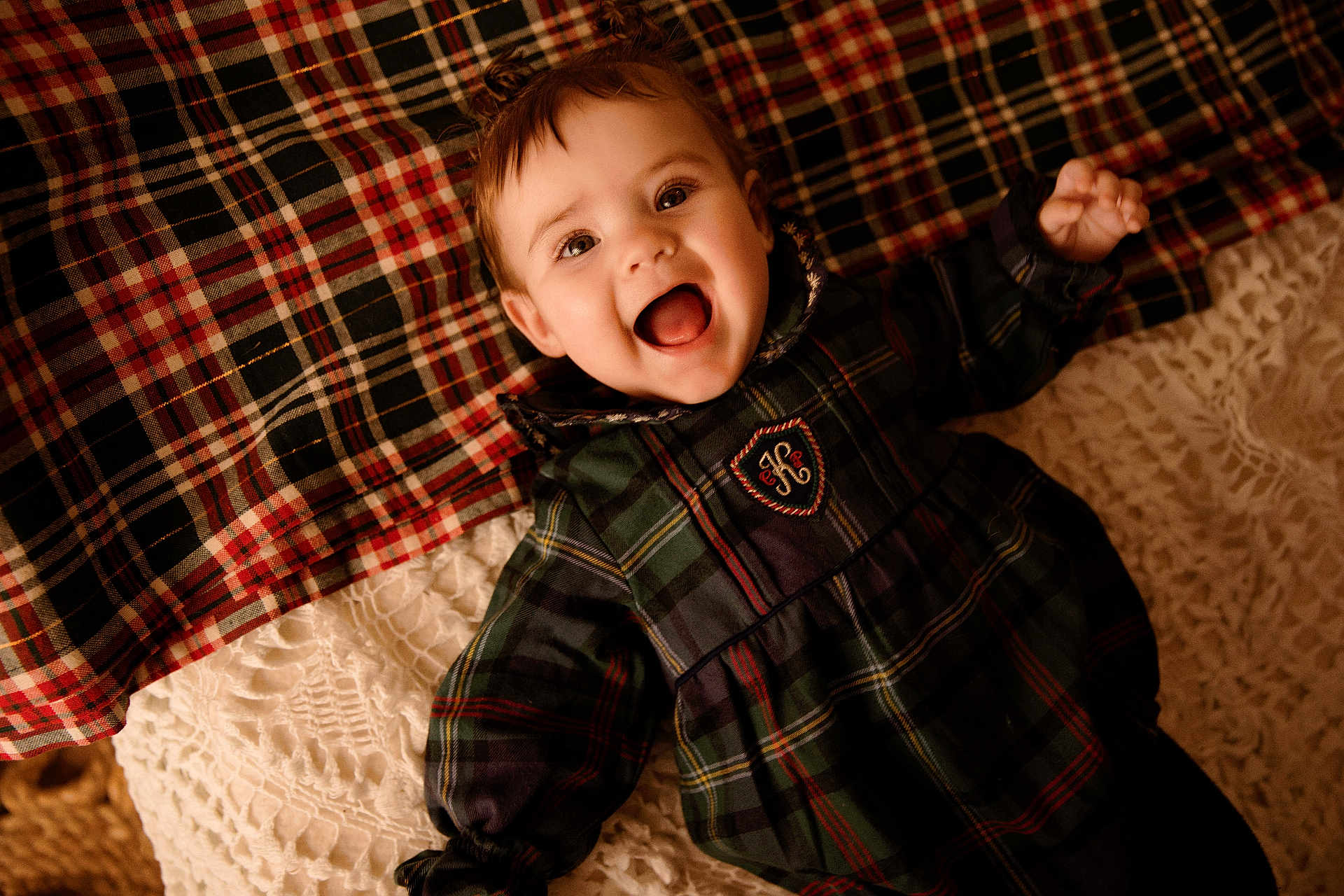 Judith participe au concours pour gagner de l'argent avec cette photo : baby, child, infant, smile, open_mouth, happy, plaid, blanket, pillow, bedding, pattern, dress, clothing, portrait, face, eyes, hair, indoor, cozy, texture