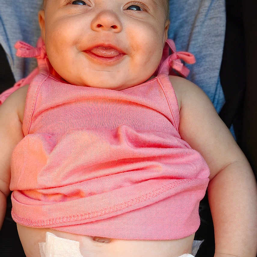 Maëly participe au concours pour gagner de l'argent avec cette photo : arms, baby, babywear, cheeks, child, closeup, clothing, cute, cute_expression, diaper, face, happy, infant, legs, pink_top, playful, sitting, skin, smile, toddler