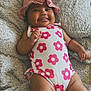 baby, blanket, cheeks, child, comfortable, cute, flower_pattern, happy, hat, indoors, infant, lying_down, pink, playful, portrait, skin, smiling, swimsuit, texture, tongue_out