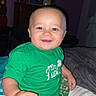 Lenox is registered to the contest to win money with this photo: baby, child, smiling, green_shirt, football_pants, bed, indoor, person, happy, cute, blue_eyes, sitting, pajamas, home, cozy, infant, portrait, young_child, casual, fun