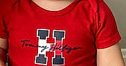 Lenox is registered to the contest to win money with this photo: toddler, child, red_shirt, tommy_hilfiger, smile, short_hair, casual_clothing, grey_pants, standing, indoor, person, cute, young_child, portrait, confident, light_skin, baby, fashion, clothing, background