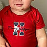 toddler, child, red_shirt, tommy_hilfiger, smile, short_hair, casual_clothing, grey_pants, standing, indoor, person, cute, young_child, portrait, confident, light_skin, baby, fashion, clothing, background