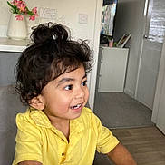 Nived joined the competition — help win amazing prizes! cabinet, carpet, child, curly_hair, door, flowers, furniture, hair_bun, happy, indoor, light_switch, person, room, smile, table, television, toddler, vase, yellow_shirt