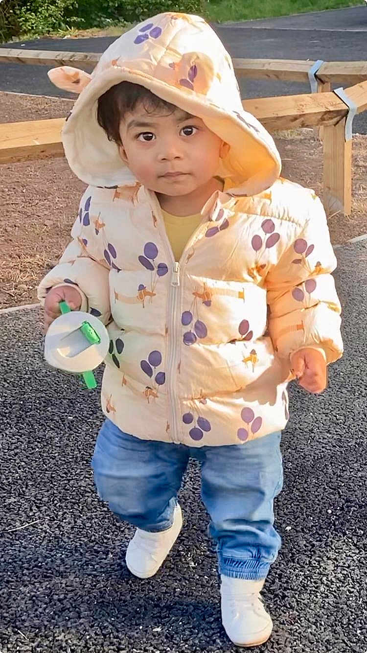 Nived joined the competition — help win amazing prizes! blue_jeans, casual, child, cute, daylight, expression, fence, footwear, gravel, hood, jacket, nature, outdoor, park, person, playful, toddler, toy, walking, young_child