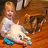 Iceee joined the competition — help win amazing prizes! toddler, child, cat, dog, toy_car, toy_racecar, wooden_floor, indoor, pet, playing, happy, sitting, white_cat, brown_dog, casual_clothing, floor, home, curious, cuddling, childhood