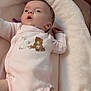 animal_print, baby, baby_nest, child, comfort, cozy, curious, cute, face, indoors, infant, lying_down, newborn, onesie, person, pink_clothing, plush_bed, small_hands, small_legs, soft_texture