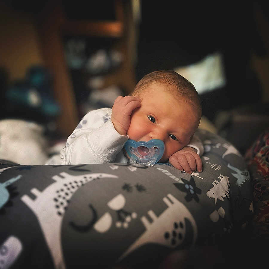 Oliver is registered to the contest to win money with this photo: baby, bed, bedroom, blanket, bodypart, couch, cushion, face, finger, furniture, hand, head, homedecor, indoors, newborn, person, photography, portrait, quilt, room
