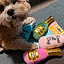 dog, plush_toys, carpet, toy_bottles, champagne, pink_toy, blue_toy, green_toy, pet, indoor, cute, fluffy, playful, soft_toys, animal, close_up, pet_toys, relaxed, home, cozy