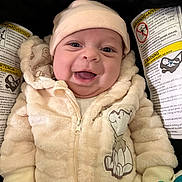Destiny joined the competition — help win amazing prizes! baby, infant, smiling, cute, jacket, hat, car_seat, warning_labels, cozy, child, happy, apparel, clothing, face, person, sitting, indoors, portrait, young_child, warm