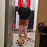 Aramis a rejoint le concours — aidez-le/la à gagner de superbes lots ! child, dog, indoor, smiling, standing, reflection, floor, tile_floor, shorts, black_shirt, relaxed, pet, animal, casual, home, red_background, white_background, black_background, person, calm