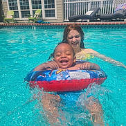 Jaylen joined the competition — help win amazing prizes! toddler, child, pool, water, float_ring, splashing, smiling, summer, swimming, outdoor, sunlight, happy, fun, play, backyard, house, fence, lawn_chair, relaxation, family