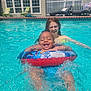 toddler, child, pool, water, float_ring, splashing, smiling, summer, swimming, outdoor, sunlight, happy, fun, play, backyard, house, fence, lawn_chair, relaxation, family