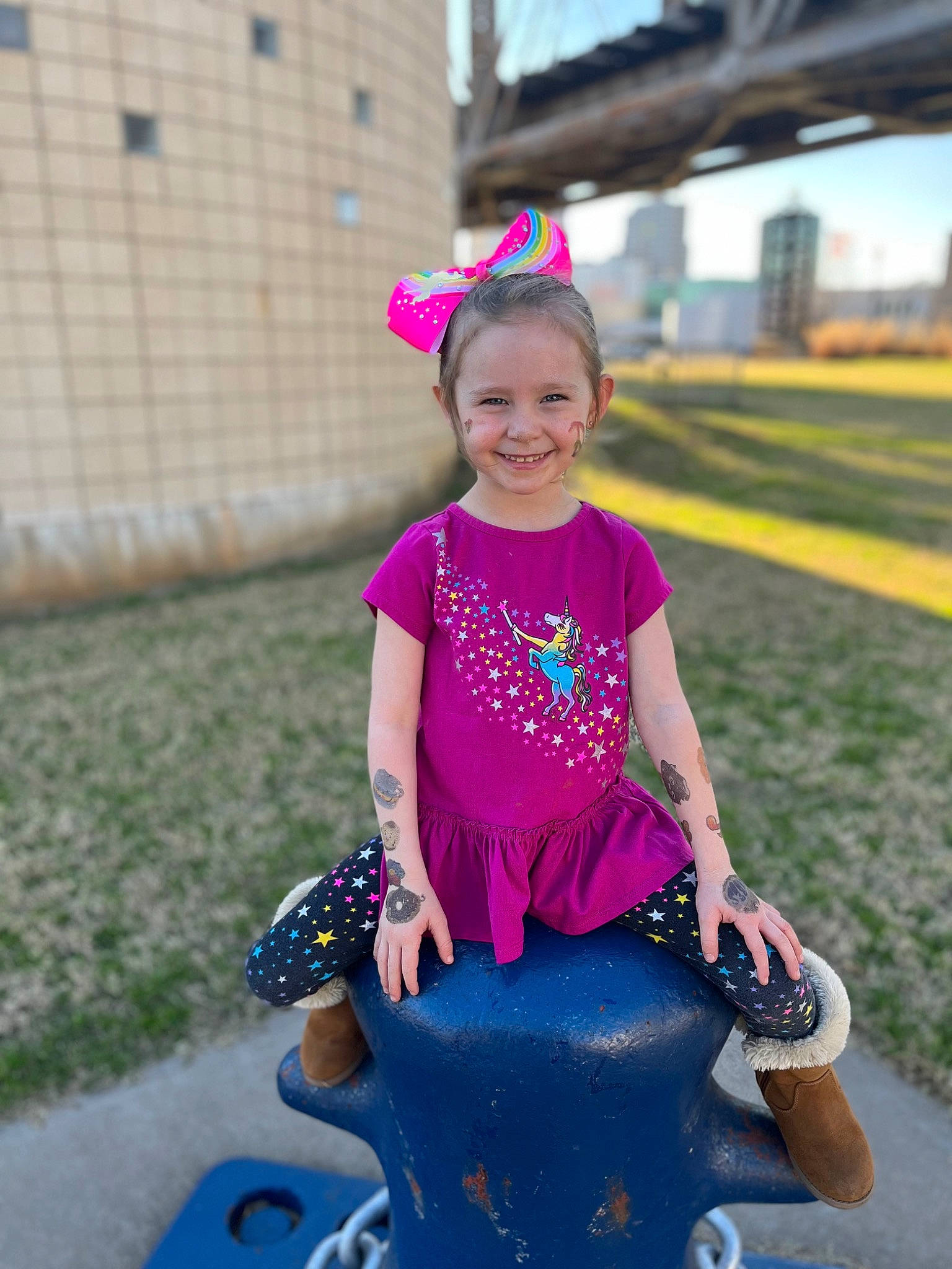 Kendall is registered to the contest to win money with this photo: child, electric_blue, fun, grass, happy, hat, helmet, joy, leisure, magenta, person, pink, plant, public_space, purple, recreation, sitting, sky, sleeve, smile