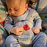 baby, infant, child, sleeping, seated, activity_seat, bib, striped_clothing, blue_clothing, hands, face, portrait, cartoon_monkey, toy, colorful_background, indoor, nursery, highchair, baby_gear, photograph