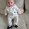 baby, infant, child, couch, clothing, white, polka_dot, sitting, cute, milestone, sign, decor, texture, footwear, portrait, indoors, person, soft_light, expression, face