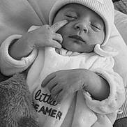 Alyana a rejoint le concours — aidez-le/la à gagner de superbes lots ! baby, infant, sleeping, beanie, hat, onesie, blanket, hand, face, cute, cozy, soft, clothing, newborn, peaceful, portrait, child, resting, indoor, black_and_white