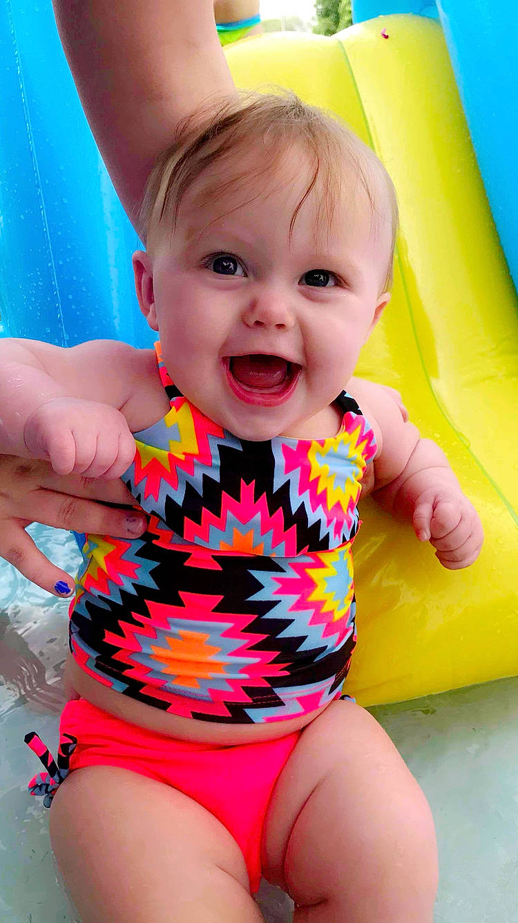 Kynsleigh joined the competition — help win amazing prizes! baby, baby_products, baby_toddler_clothing, child, inflatable, one_piece_swimsuit, person, product, smile, swimwear, toddler