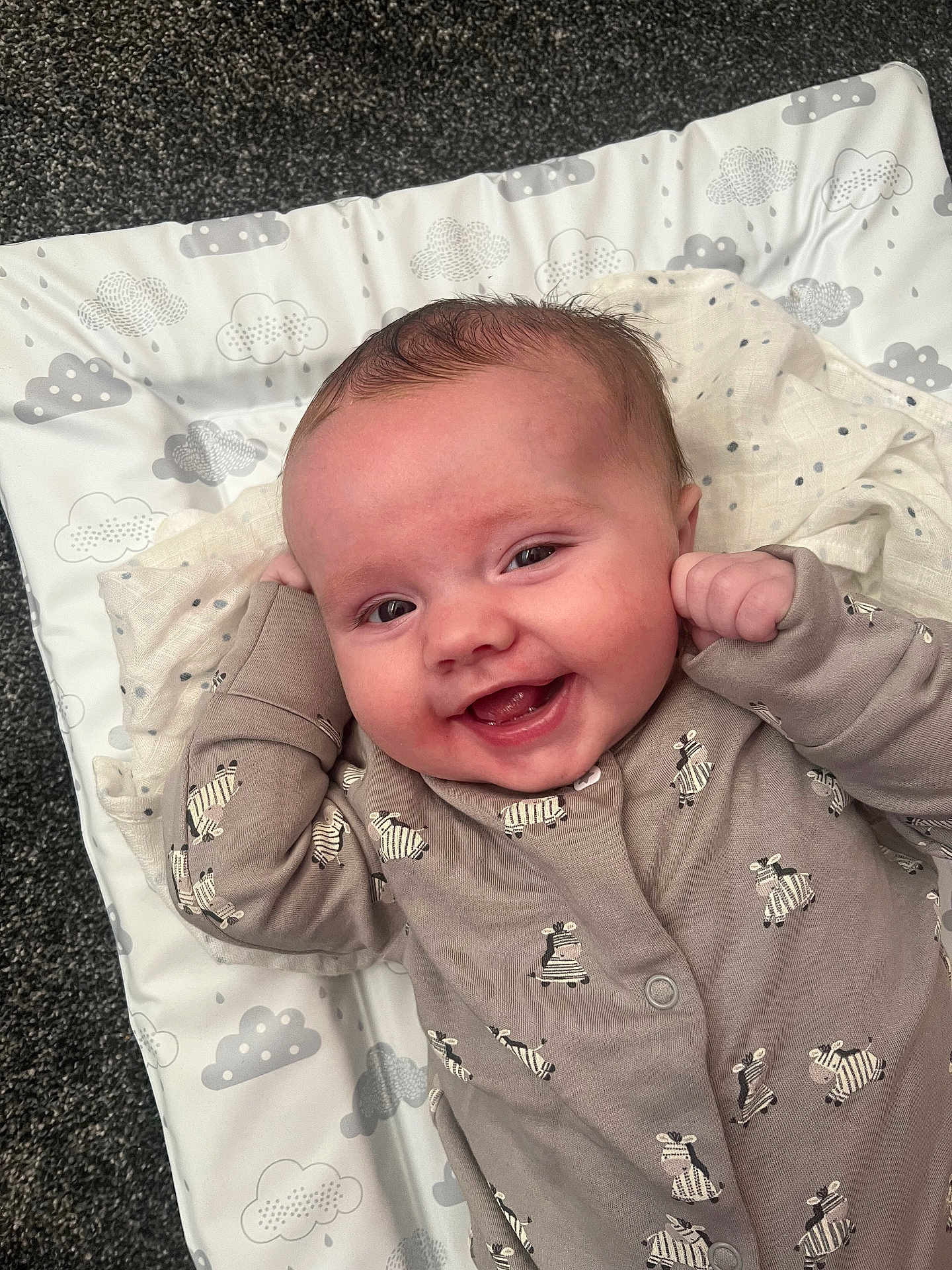 Jaxon joined the competition — help win amazing prizes! baby, infant, smile, onesie, zebra_pattern, cute, happy, lying_down, soft_mat, cloud_pattern, fist, small_hands, face, cheeks, indoor, carpet, child, expression, joy, portrait