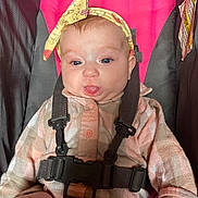 Allie joined the competition — help win amazing prizes! baby, child, headband, car_seat, pink, gray, clothing, straps, tongue, face, cute, infant, sitting, apparel, seatbelt, expression, human, young, indoors, portrait