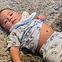 Sebastian is registered to the contest to win money with this photo: baby, infant, child, lying_down, carpet, plush, cute, clothing, cartoon_print, face, hand, skin, toddler, indoors, portrait, expression, comfort, relaxing, young, casual