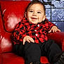 baby, child, smiling, red_chair, checkered_shirt, black_pants, black_shoes, indoor, portrait, holiday_theme, reindeer_silhouette, moon, winter_background, cute, happy, seated, infant, fashion, cozy, festive