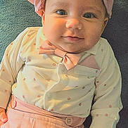 Sebastian is registered to the contest to win money with this photo: baby, child, infant, hat, bow_tie, polka_dots, pink_clothing, smile, face, hand, cute, portrait, lying_down, soft_texture, pastel_colors, fashion, apparel, adorable, young, happy