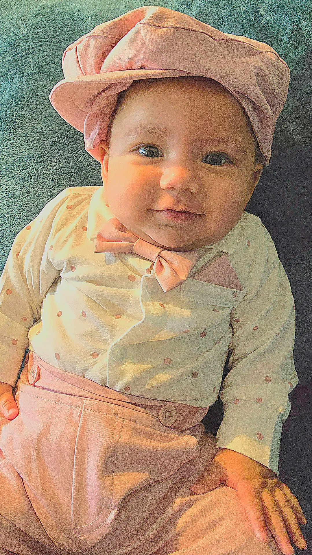 Sebastian is registered to the contest to win money with this photo: baby, child, infant, hat, bow_tie, polka_dots, pink_clothing, smile, face, hand, cute, portrait, lying_down, soft_texture, pastel_colors, fashion, apparel, adorable, young, happy