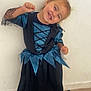 Mia participe au concours pour gagner de l'argent avec cette photo : black, blue, boots, child, costume, cute, dress, fashion, floor, footwear, fun, happy, indoor, joyful, person, posing, smile, toddler, wall, young