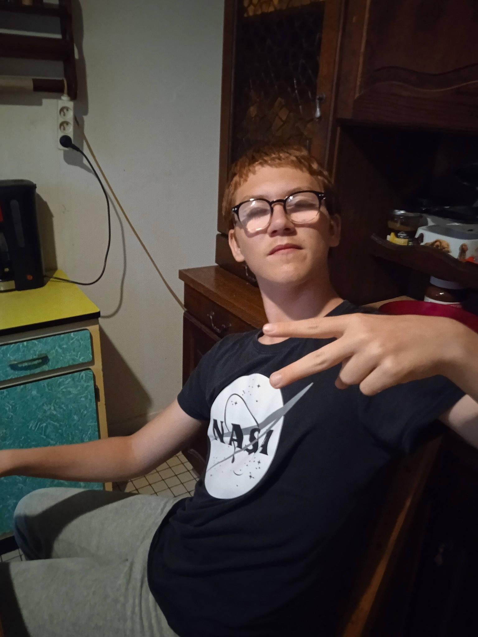 Anzo participe au concours pour gagner de l'argent avec cette photo : audio_equipment, chair, comfort, elbow, event, eyewear, finger, flash_photography, fun, gadget, gesture, glasses, human_leg, knee, person, sitting, t_shirt, thigh, thumb, vision_care