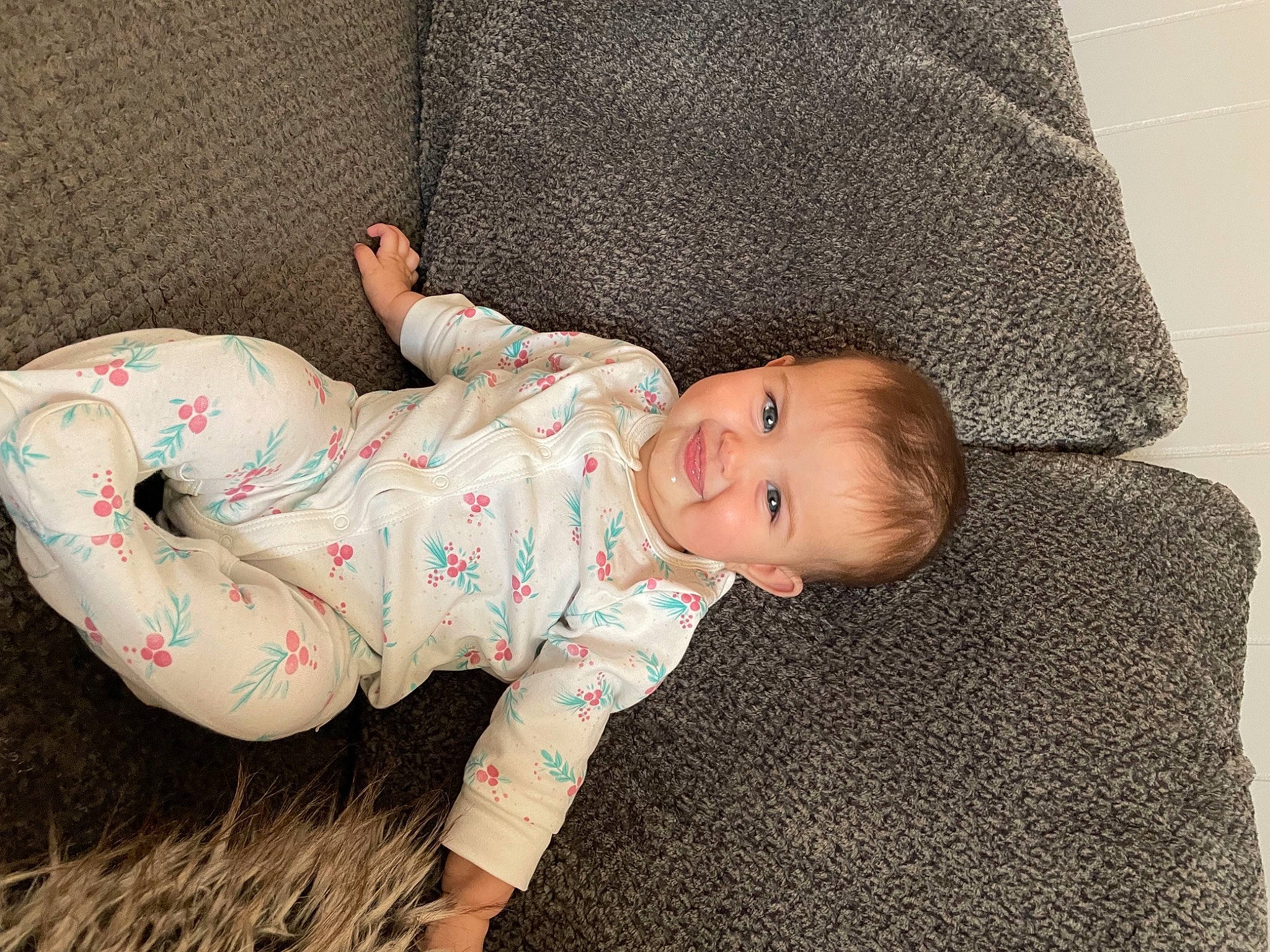 Elsie is registered to the contest to win money with this photo: baby, baby_products, baby_toddler_clothing, cheek, child, comfort, foot, grass, joy, linens, nightwear, pattern, person, sitting, skin, sleeve, sock, textile, toddler, wood