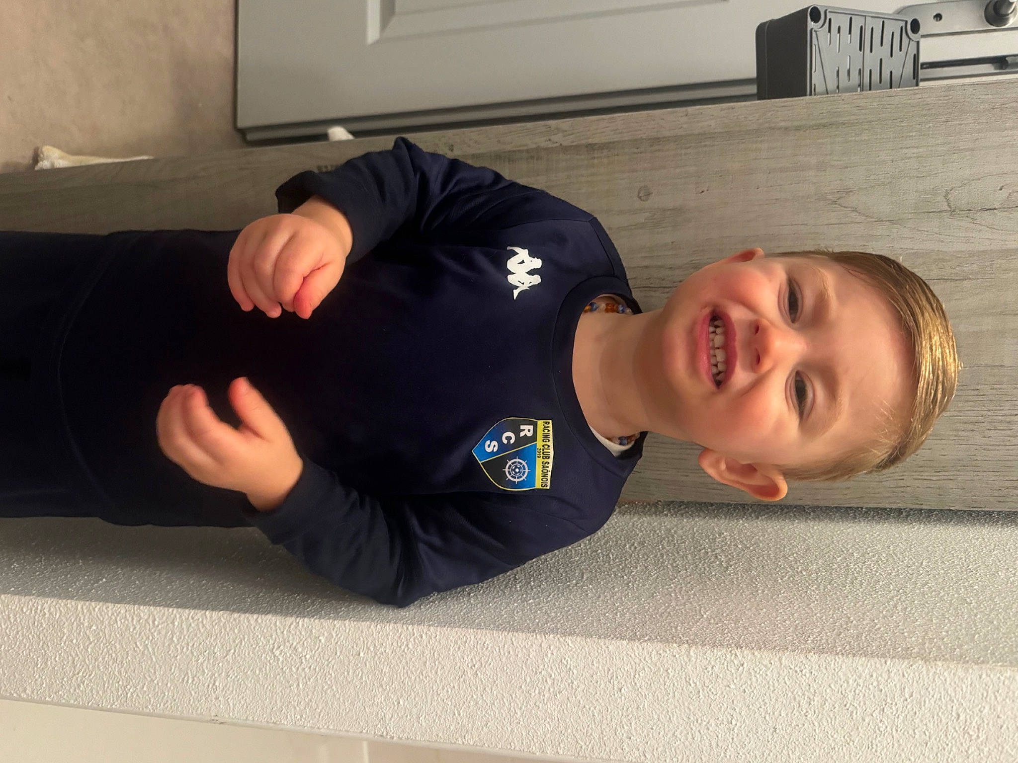 Ayden participe au concours pour gagner de l'argent avec cette photo : arm, comfort, elbow, flooring, foot, happy, hip, human_leg, joint, joy, knee, long_sleeved_t_shirt, person, picture_frame, room, sleeve, smile, sportswear, t_shirt, thigh