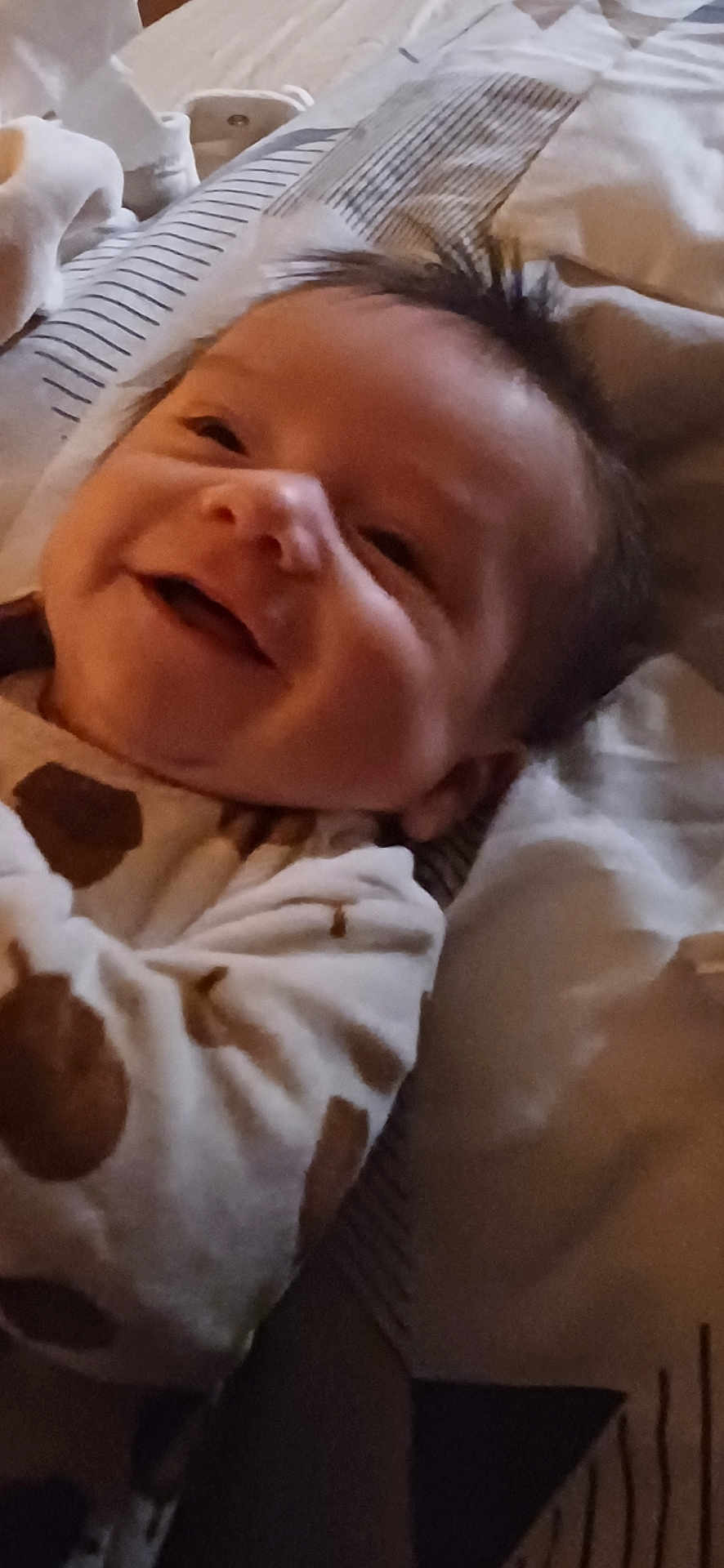 Isaac a rejoint le concours — aidez-le/la à gagner de superbes lots ! baby, infant, smiling, face, hair, pajamas, polka_dots, blanket, bedding, pillow, lying_down, portrait, closeup, happy, cheeks, mouth, eyes, skin, indoors, cozy