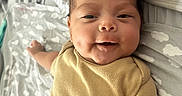 Alexander joined the competition — help win amazing prizes! baby, infant, smiling, onesie, bed, pillow, blanket, sleepwear, child, cute, happy, lying_down, face, skin, head, arm, indoors, person, newborn, resting