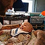 baby, adult, tattoo, smile, bib, playpen, television, furniture, room, clothing, happy, face, person, interaction, home, infant, closeup, portrait, indoor, parent
