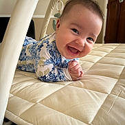 Charli joined the competition — help win amazing prizes! baby, infant, smiling, lying_down, onesie, floral_pattern, quilted_mat, indoor, happy, cute, child, face, hands, head, baby_toy, soft, portrait, person, warm_lighting, home