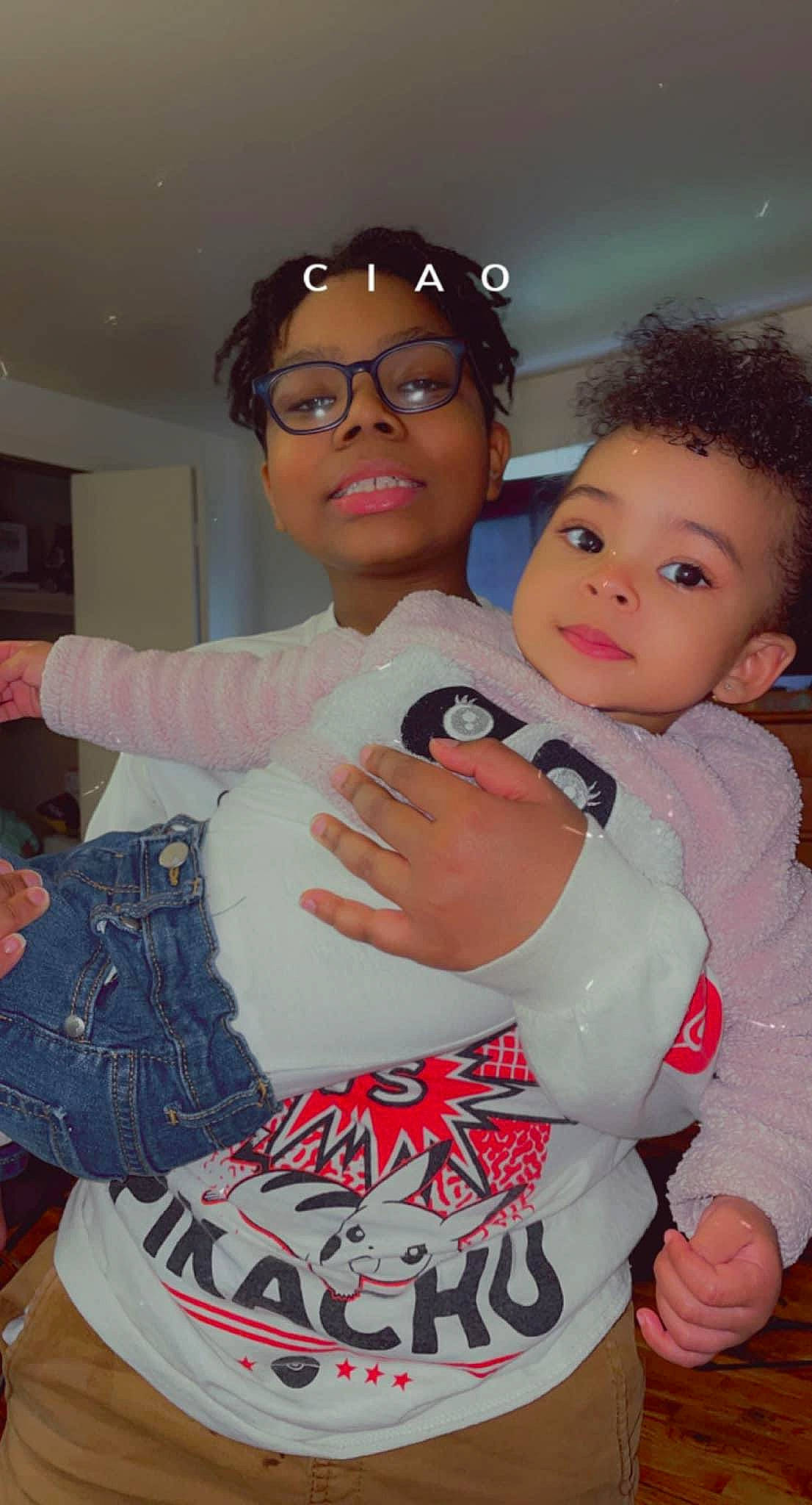 Israel is registered to the contest to win money with this photo: baby_toddler_clothing, cheek, child, cool, finger, gesture, glasses, happy, interaction, joint, muscle, person, pink, shoulder, skin, sleeve, standing, thumb, trunk, vision_care