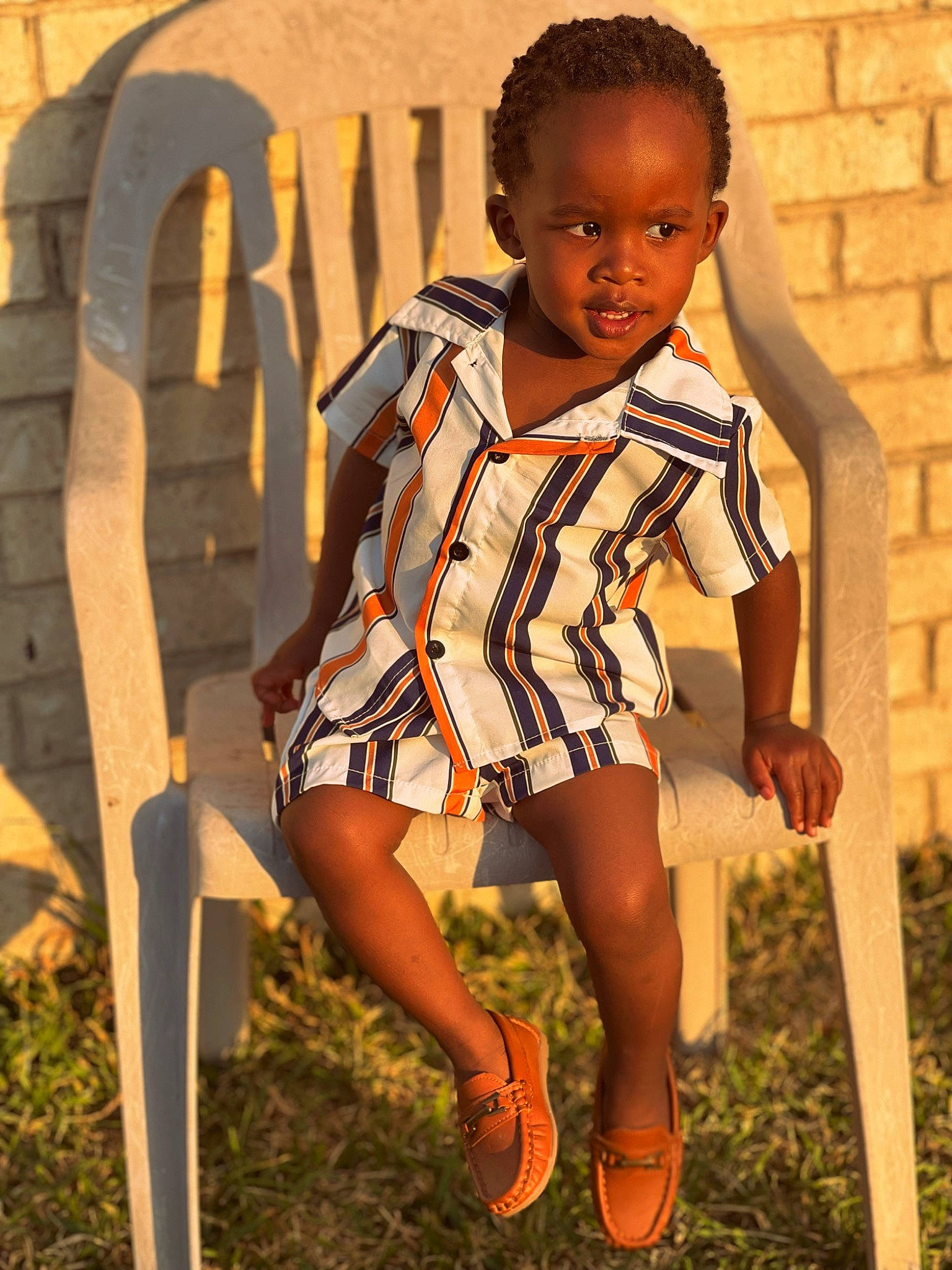 Reginald is registered to the contest to win money with this photo: black_hair, cool, dress, face, facial_expression, grass, hair, hairstyle, happy, head, human_body, knee, leaf, neck, people_in_nature, person, standing, street_fashion, sunlight, t_shirt