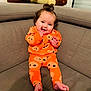 Aliénor participe au concours pour gagner de l'argent avec cette photo : baby, child, pajamas, orange_clothing, smile, happy, sitting, couch, plush_toy, indoor, curly_hair, footwearless, face, hands, window, home, comfort, cute, infant, playful
