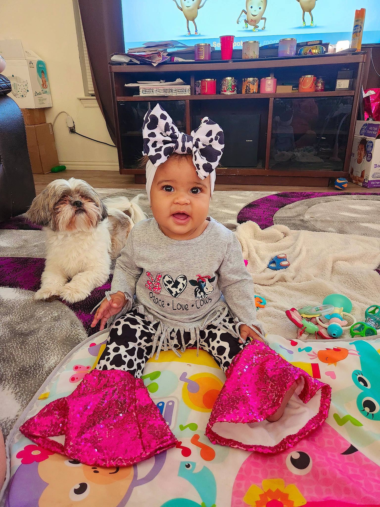 Mariah is registered to the contest to win money with this photo: art, baby, baby_toddler_clothing, child, companion_dog, costume_hat, event, fun, happy, hat, headgear, headwear, magenta, person, picture_frame, pink, purple, room, snapshot, television