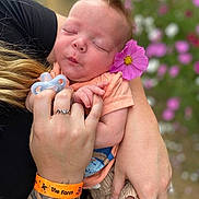 Kasun Eli joined the competition — help win amazing prizes! baby, flower, hand, tattoo, wristband, pacifier, pink_flower, nature, outdoor, person, sleeping, child, skin, arm, holding, flower_garden, blurred_background, peaceful, casual_clothing, closeup