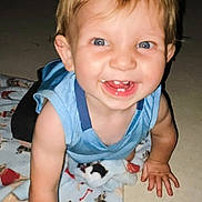 Houston Lane is registered to the contest to win money with this photo: toddler, child, smiling, crawling, blanket, blue_eyes, indoor, happy, baby, cute, clothing, short_sleeves, person, floor, playful, animal_print, young_child, infant, face, joy