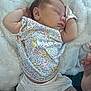 baby, sleeping, infant, floral_clothing, white_shorts, blanket, soft_texture, peaceful, cute, child, newborn, resting, portrait, indoors, skin, hand, face, head, lying_down, cozy