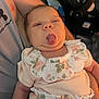 Alora is registered to the contest to win money with this photo: baby, infant, face, tongue_out, floral_clothing, person, arm, sleeveless_shirt, holding, cute, expression, indoors, blurred_background, skin, head, mouth, eyes, chubby_cheeks, human, child