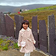 Flora is registered to the contest to win money with this photo: casual, child, cloudy_sky, coat, countryside, fall, fashion, girl, grass, leggings, nature, outdoor, path, pink_purse, portrait, scenic, smile, sneakers, stone_fence, young