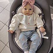 Alma participe au concours pour gagner de l'argent avec cette photo : baby, baby_seat, blue, bow, child, cushion, embroidery, floor_tiles, flowers, grey, headband, indoor, infant, pants, person, pink, portrait, socks, sweater, white